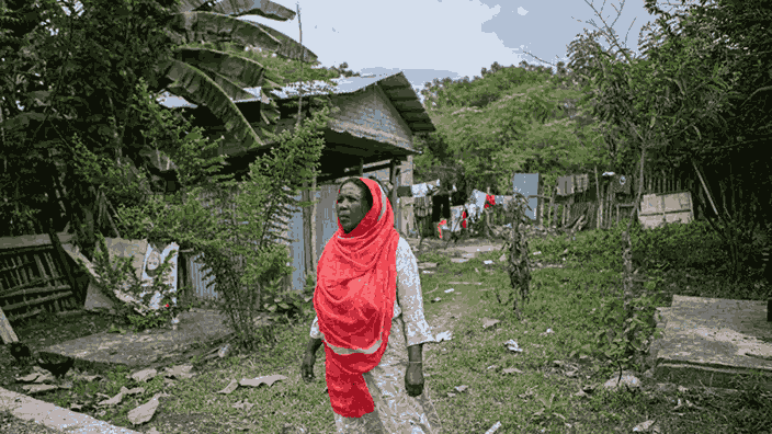 Setelah melihat cucunya yang tinggal di sebuah rumah yang masuk ke kawasan pertambangan bebatuan di Kelurahan Buluri, Palu, Sulawesi Tengah, pada Sabtu 25 Mei 2024, masyarakat berjalan. Gambar oleh BBC Indonesia.