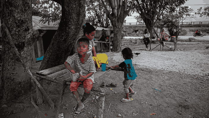 Seorang anak duduk di depan rumahnya yang masuk ke kawasan lingkar tambang di Kelurahan Buluri, Palu, Sulawesi Tengah, pada tanggal 25 Mei 2024. Gambar oleh BBC Indonesia