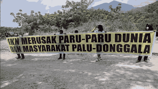 Empat warga yang tergabung dalam Koalisi Petisi Palu-Donggala berunjuk rasa di lingkar tambang bebatuan di Kelurahan Buluri, Palu, Sulawesi Tengah, pada 21 Mei 2024. Mereka menyebarkan spanduk yang berbunyi IKN merusak paru-paru dunia dan masyarakat Palu-Donggala. Gambar oleh BBC Indonesia